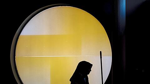 Eine Frau mit einem Wagen für Reinigungsmaterial steht vor einem runden Fenster der Berliner Philharmonie. Um Lohndumping entgegenzuwirken, hat der Gesetzgeber in zahlreichen Bereichen, darunter das Gebäudereinigungsgewerbe, branchenspezifische Mindestlöhne eingeführt.