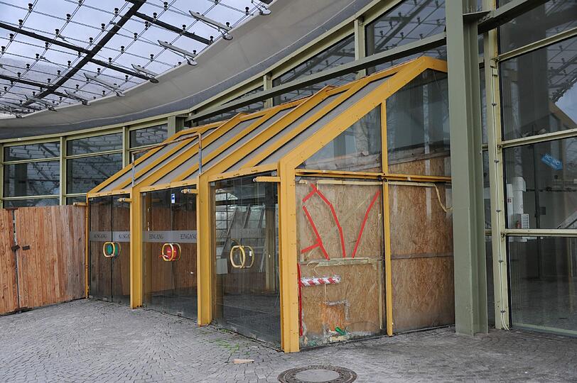 Kaputte Scheiben, provisorisch repariert: Ein verschlossener Seiteneingang der Olympia-Schwimmhalle.