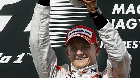 Heikki Kovalainen jubelt über seinen Sieg in Ungarn.