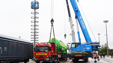 Auf dem Messegelände werden Waggons und Loks von Schienen auf Tieflader umgeladen, damit sie auf der Messe präsentiert werden können.