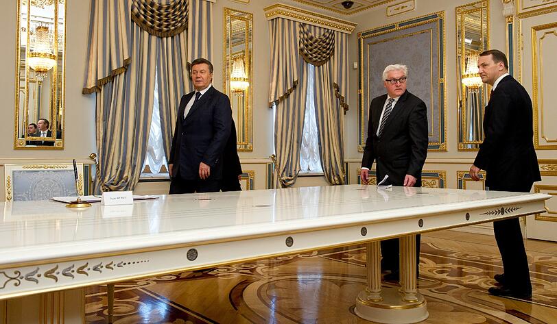 Der ukrainische Staatspräsident Viktor Janukowitsch (links),  Bundesaußenminister Frank-Walter Steinmeier (SPD) und der polnische Außenminister Radoslaw Sikorski im Präsidentenpalast in Kiew nach der Unterzeichnung einer vorläufigen Vereinbarung zur Lösung der innenpolitischen Krise.