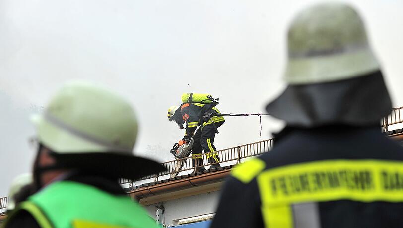 Feuerwehrleute löschen am Freitag in Karlsfeld (Oberbayern) ein brennendes Gebäude. Aus unbekannter Ursache war in dieser Halle eines Dachdeckerbetriebes ein Brand ausgebrochen. Feuerwehrleute löschen am Freitag in Karlsfeld (Oberbayern) ein brennendes Gebäude. Aus unbekannter Ursache war in dieser Halle eines Dachdeckerbetriebes ein Brand ausgebrochen.