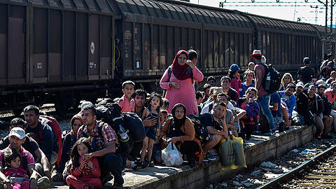 Flüchtlinge warten nahe der serbischen Grenze auf einen Zug. Viele führt es nach Deutschland. Der Bund will Länder und Kommunen jetzt noch mehr unterstützen.