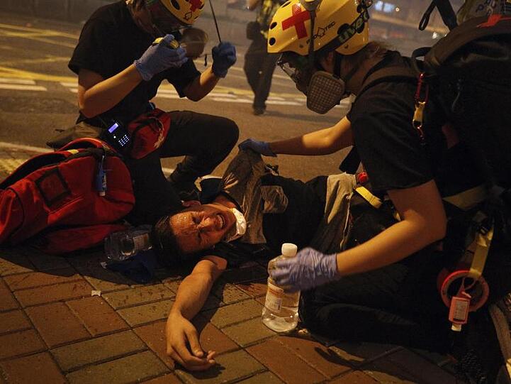 Sanitäter helfen einem von Tränengas getroffenen Demonstranten.