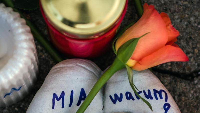Eine Skulptur in Form zweier Handflächen mit der Aufschrift "Mia warum?" und eine Rose liegen vor dem Drogeriemarkt, in die 15-jährige Mädchen von ihrem Ex-Freund erstochen wurde.