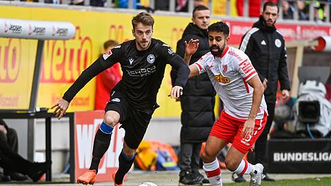 Sarpreet Singh von Regensburg (r) kämpft mit Lukas Klünter von Bielefeld um den Ball.