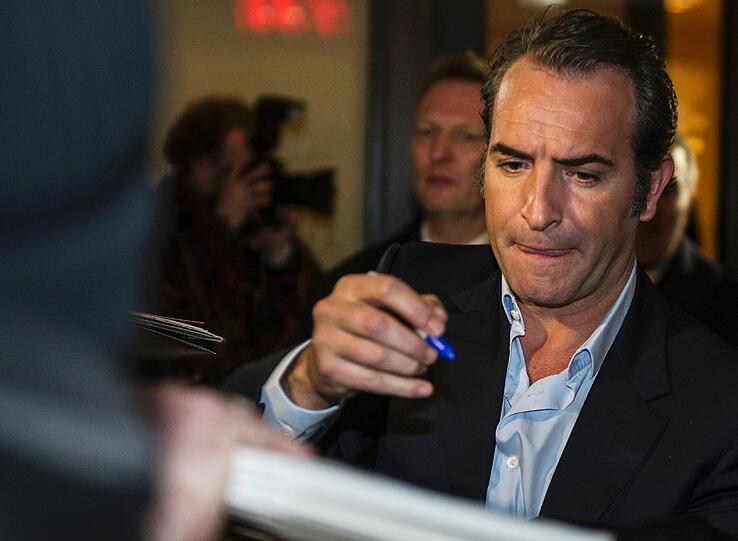 Der französische Schauspieler Jean Dujardin gibt Autogramme am 08.02.2014 vor dem Restaurant Bocca di Bacco in Berlin. Dort feierte der US-amerikanische Schauspieler George Clooney die Berlinale-Premiere des Films "The Monuments Men" mit geladenen Gästen.
