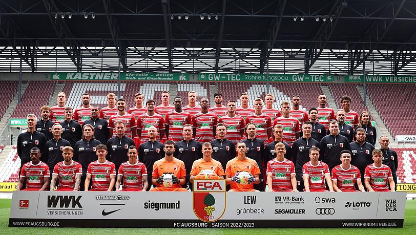 Spieler und Offizielle, stehen beim Mannschaftsfototermin des FC Augsburg in der WWK-Arena zusammen.