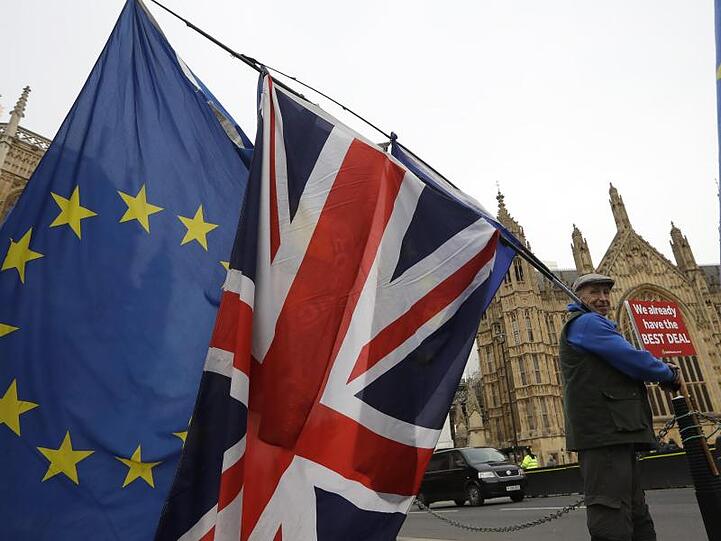 Ein Demonstrant protestiert mit einer EU-Fahne und der Nationalflagge des Vereinigten Königreichs vor dem Parlament in London.