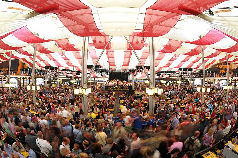 Gäste feiern und trinken im Festzelt.