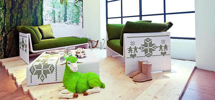 Norwegermuster auf dem Sofa, Baumrinde und Dekoschaf: Die Farbe Grün verbindet alles harmonisch.