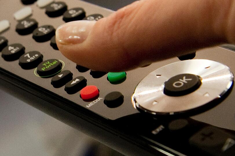 Ein Daumen schwebt am (03.09.2010) auf der Internationalen Funkausstellung IFA in Berlin über dem roten Knopf einer Fernbedienung. Das Zusammenwachsen von TV und Internet wird auf der Funkausstellung IFA in Berlin schon seit Jahren heiß diskutiert.