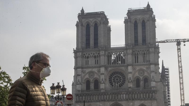 Ein Mann mit Mundschutz vor der Baustelle der Kathedrale Notre Dame in Paris. Ein Mann mit Mundschutz vor der Baustelle der Kathedrale Notre Dame in Paris.