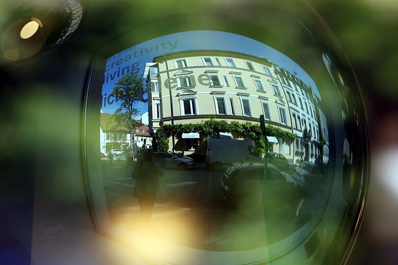 Hingucker im Lampenladen: Im Schaufenster spiegeln sich die Gebäude.
