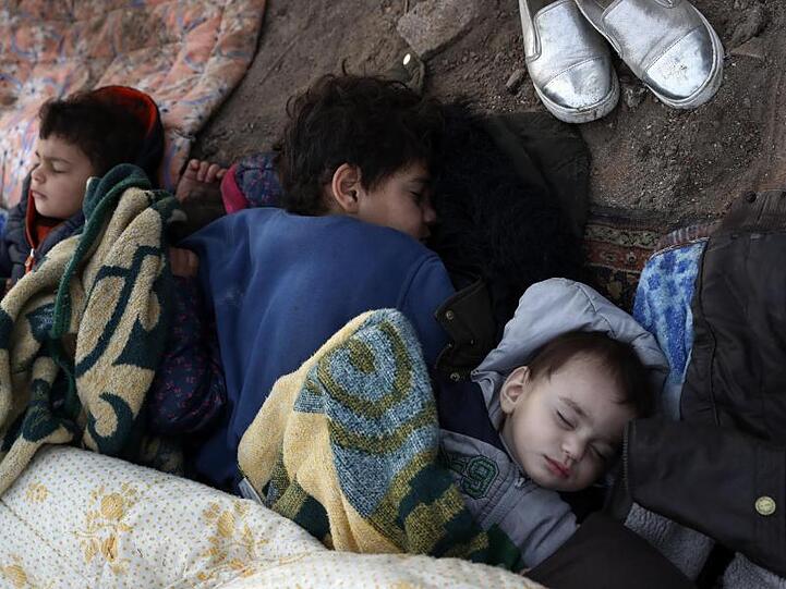 Kinder liegen schlafend auf dem Boden nahe der türkisch-griechischen Grenze.