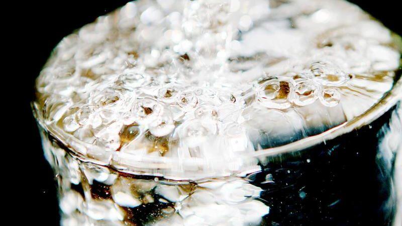 Ein Glas läuft voll Trinkwasser. Foto: Oliver Berg/Archivbild