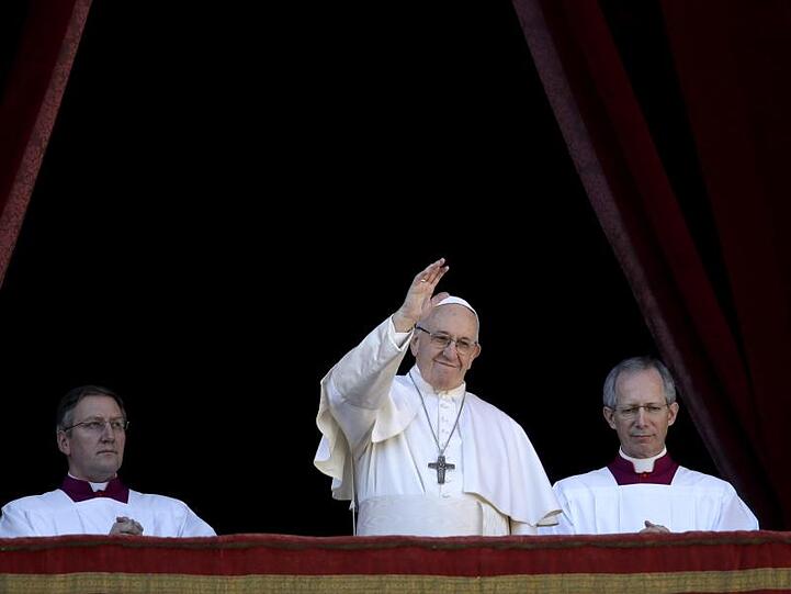 Papst Franziskus (M) winkt vom Hauptbalkon der Peterskirche im Vatikan.