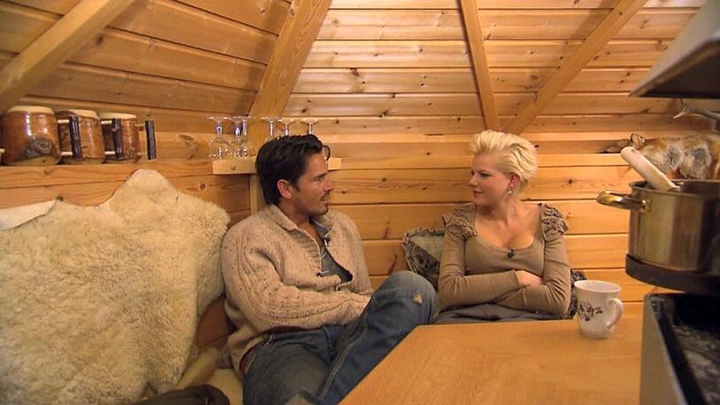 In der romantischen Gartenhütte am Feuer können Melanie und der Bachelor ungestört reden.