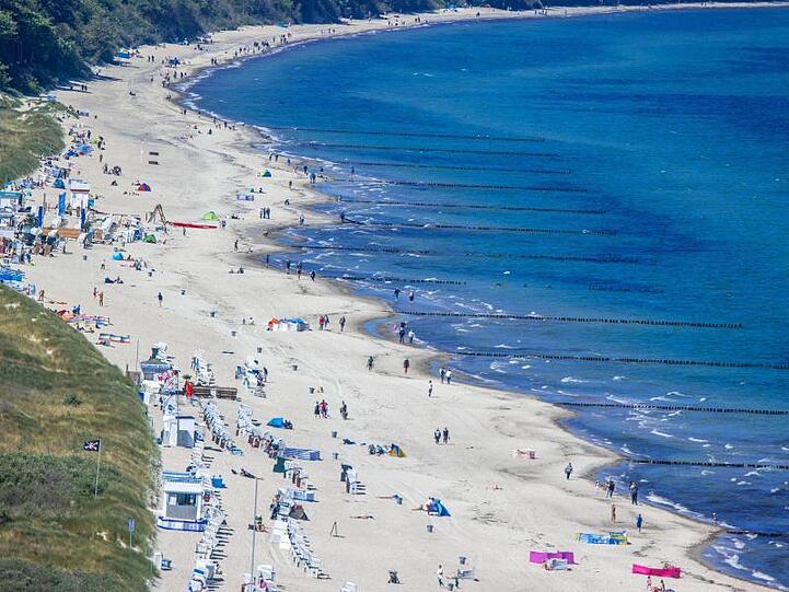 Urlauber genießen das Sonnenwetter am Ostseestrand.