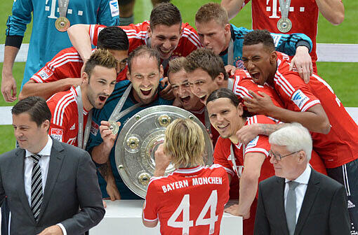 Die Mannschaft des FC Bayern feiert mit der Meisterschale.