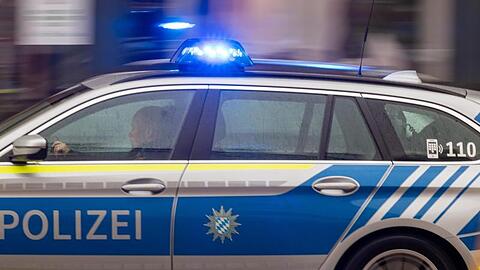 Ein Polizeiwagen fährt mit Blaulicht durch die Innenstadt.