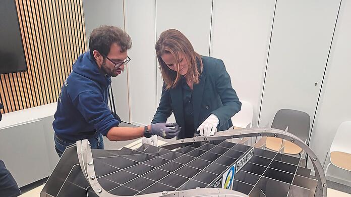 Proxima-Fusion-Magnetingenieur Nicolò Riva weist die Vorstandsvorsitzende des Startup-Verbands, Verena Pausder, in die Geheimnisse des neuentwickelten Hochtemperatur-Superleiters ein.