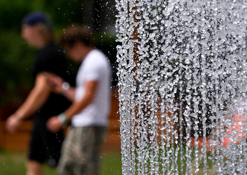 Zwei Männer gehen vor dem Lenbachhaus an einem Springbrunnen entlang. In München ist die Bevölkerung zum Wassersparen angehalten. Zwei Männer gehen vor dem Lenbachhaus an einem Springbrunnen entlang. In München ist die Bevölkerung zum Wassersparen angehalten.