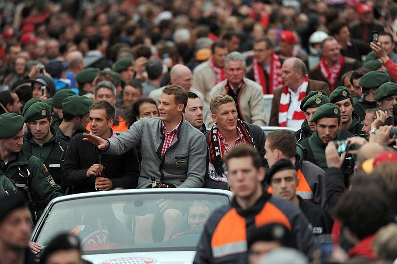 Das Cabrio mit Manuel Neuer, Bastian Schweinsteiger und Philipp Lahm bahnt sich den weg durch die Massen.