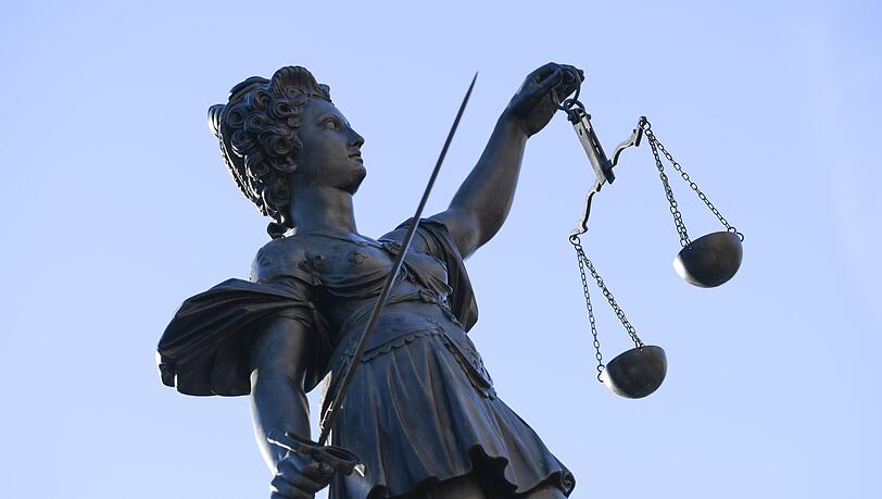 Eine Statue der Justitia steht unter freiem Himmel.