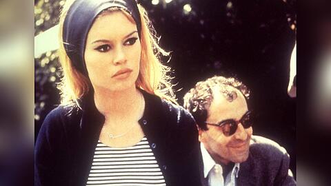 Regisseur Jean-Luc Godard sitzend hinter Brigitte Bardot am Set des Films "Le Mépris" aus dem Jahr 1963.