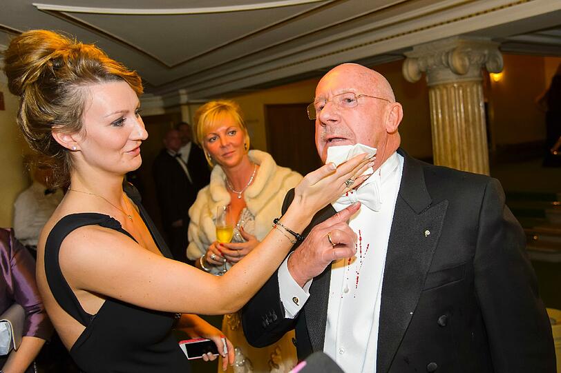 Eine Dame eilt zur Hilfe und reicht ihm ein Tuch.