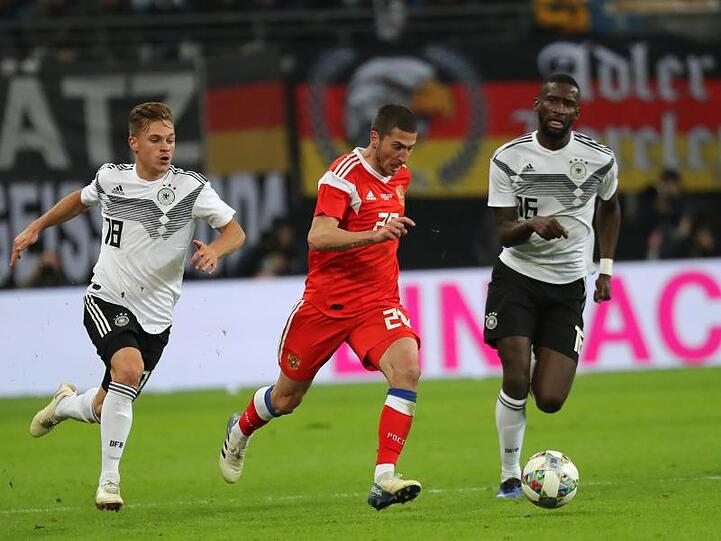 Joshua Kimmich (l) und Antonio Rüdiger (r) nehmen den Russen Alexei Ionow in die Zange.