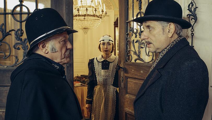 Constable Ivor Partridge (Miroslav Nemec, links) und Chief Inspector Francis Lightmyer (Udo Wachtveitl, rechts) sind vor Beckford Hall angekommen. Heather (Marie Rathscheck) öffnet.