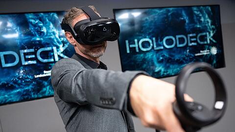 Ralf Breker, Leiter der forensischen Medientechnik beim LKA, steht mit einer VR-Brille während einer Pressekonferenz im Tatort-Virtual-Reality-Raum (Holodeck).