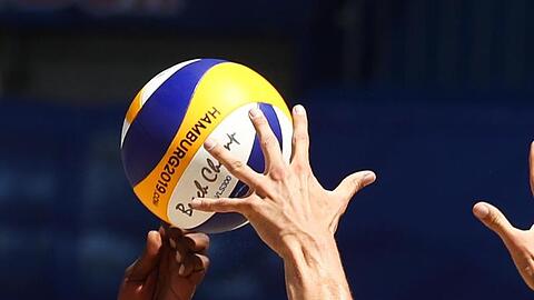 Ein Volleyball fliegt durch die Luft. Foto: Christian Charisius/dpa/Archivbild