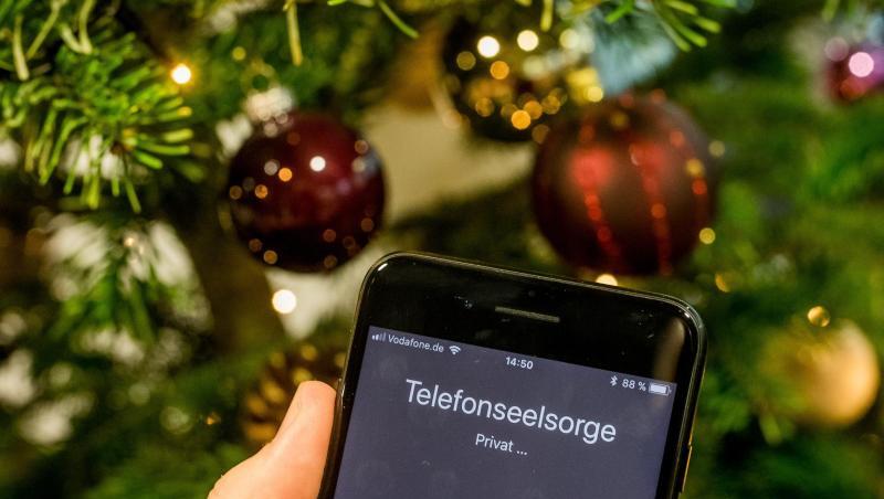 Mit einem Smartphone wird die Nummer der Telefonseelsorge vor einem Weihnachtsbaum gewählt. Foto: Michael Kappeler/Archiv Mit einem Smartphone wird die Nummer der Telefonseelsorge vor einem Weihnachtsbaum gewählt. Foto: Michael Kappeler/Archiv