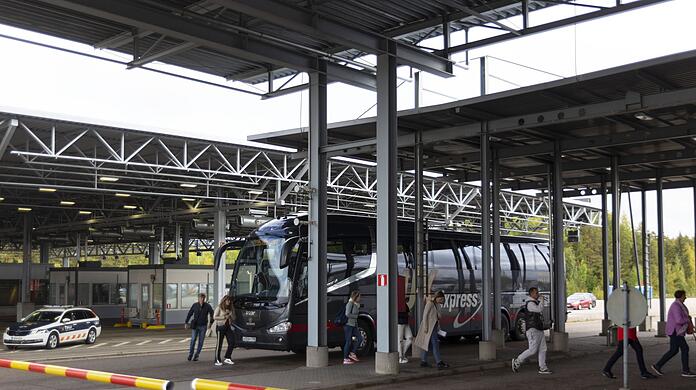 Russische Passagiere verlassen einen Bus und gehen zur Passkontrolle am Grenzübergang Vaalimaa zwischen Finnland und Russland.
