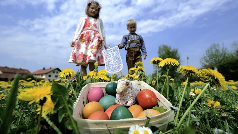Zwei Kinder suchen Ostereier. Auch Eltern ohne eigenen Garten dürften theoretisch in öffentlichen Grünanlagen Ostereier verstecken, wenn die Abstandsregel eingehalten wird. Es wird aber empfohlen, die Eier in der Wohnung zu verstecken.