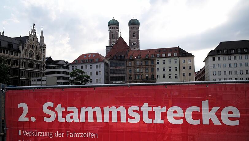 Der rote Sichtschutz der Baustelle am Marienhof. Bis zu kürzeren Fahrzeiten und besseren Kapazitäten wird es noch lange dauern.