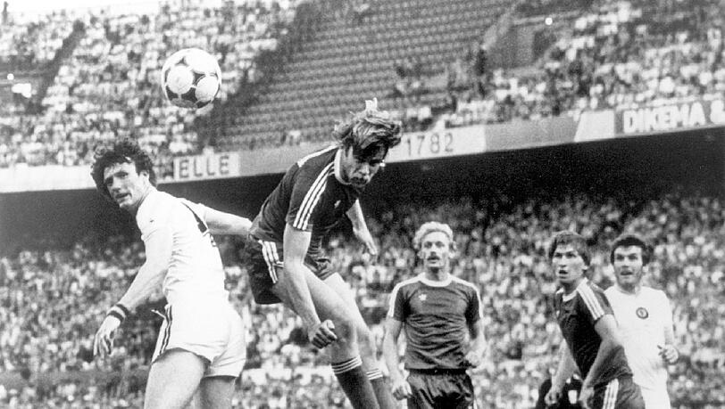 Auch 1982 gelangten die Bayern ins Finale des Pokals der Landesmeister. In Rotterdam unterlagen sie dort jedoch Aston Villa mit 0:1, trotz einer klaren Dominanz im Spielverlauf. Hier erwischt Bayern-Abwehrspieler Udo Horsmann (2.v.l) den Kopfball vor Villa-Abwehrspieler Allan Evans (l) nicht voll, der Ball geht weit am Villa-Tor vorbei. Horsmanns Teamgefährten Hans Weiner (3.v.l) und Klaus Augenthaler (2.v.r) schauen dem Ball gebannt hinterher. Auch 1982 gelangten die Bayern ins Finale des Pokals der Landesmeister. In Rotterdam unterlagen sie dort jedoch Aston Villa mit 0:1, trotz einer klaren Dominanz im Spielverlauf. Hier erwischt Bayern-Abwehrspieler Udo Horsmann (2.v.l) den Kopfball vor Villa-Abwehrspieler Allan Evans (l) nicht voll, der Ball geht weit am Villa-Tor vorbei. Horsmanns Teamgefährten Hans Weiner (3.v.l) und Klaus Augenthaler (2.v.r) schauen dem Ball gebannt hinterher.