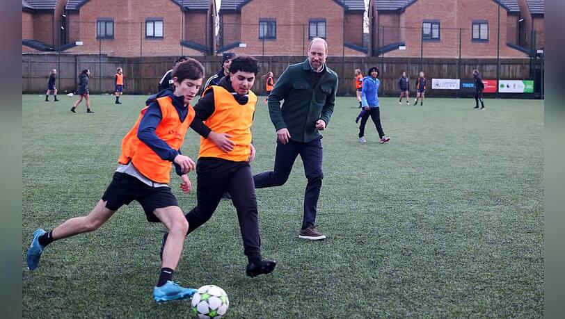 Prinz William spielt mit Teenagern Fußball.