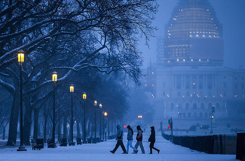 Die Ostküste der USA hat mit einem Schneesturm zu kämpfen. Bild: Passanten am Montag in Washington.