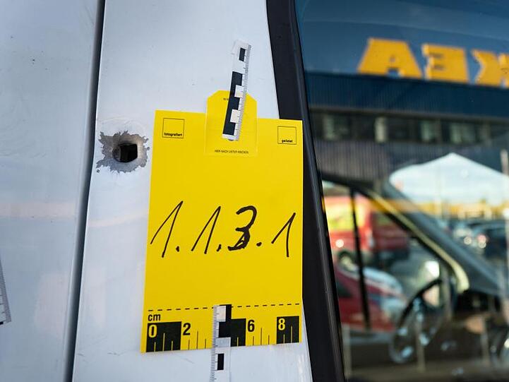 Ein von der Spurensicherung gekennzeichnetes Einschussloch vor einem Seiteneingang eines Ikea-Möbelhauses.