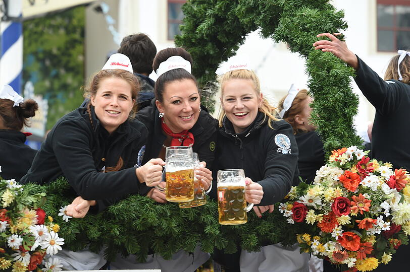 Bedienung prosten beim Einzug der Wiesnwirte auf der Theresienwiese beim Start des 187. Münchner Oktoberfest auf einem Wagen mit Maßkrügen an.