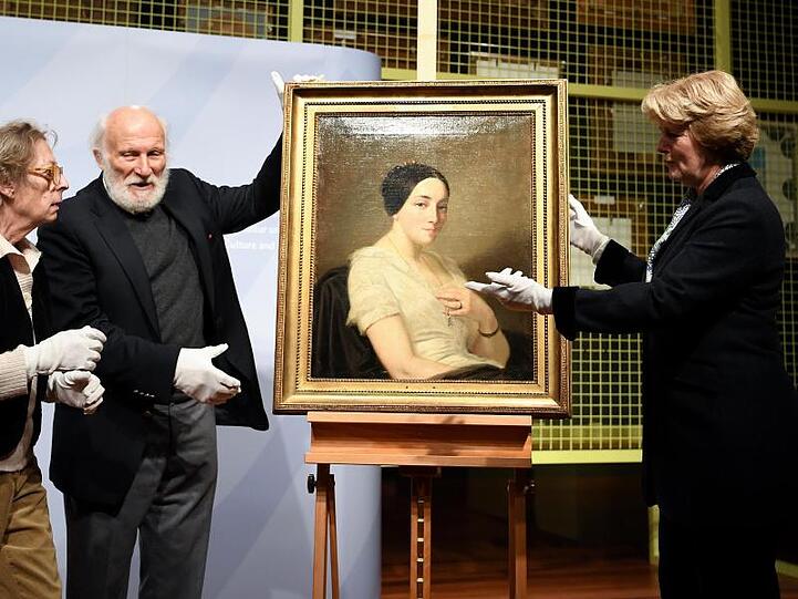 Kulturstaatsministerin Monika Grütters (r.) übergag den Erben Maria de las Mercedes Estrada und Wolfgang Kleinertz, das Bild "Portrait einer sitzenden jungen Frau / Portrait de jeune femme assise" von Thomas Couture.