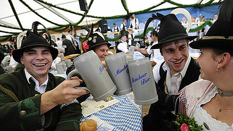 Besucher trinken gemütlich eine Mass auf der Oidn Wiesn.