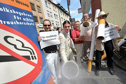 Mit überdimensionalen Zigaretten und viel Rauch aus der Maschine wirbt die ödp in der Jakobstraße für ihr Volksbegehren für echten Nichtraucherschutz. Im Hintergrund: die Nürnberger CSU-Zentrale.
