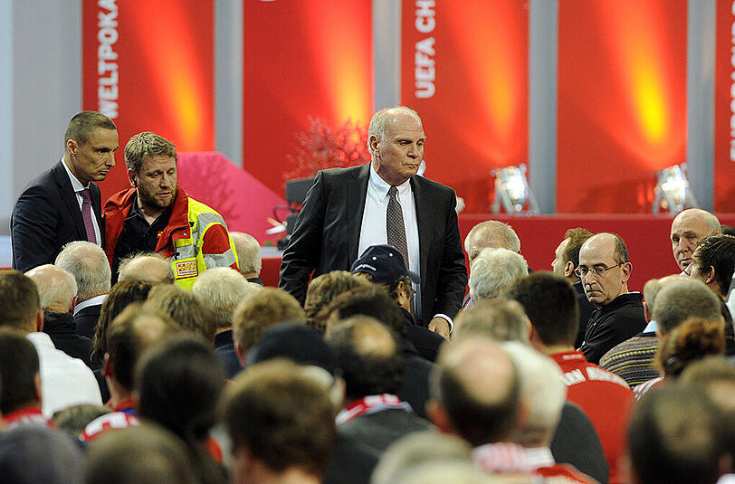 Uli Hoeneß kümmert sich um ein Vereinsmitglied des FC Bayern - der Mann war in der dritten Reihe kollabiert und wurde dann ins Krankenhaus gebracht. Rummenigge und später auch Hopfner unterbrachen den offiziellen Teil jeweils für einige Minuten.