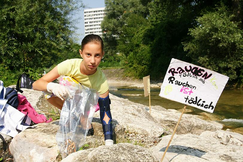 Louisa sammelt fleißig Zigarettenkippen zwischen den Felsen auf, die andere einfach liegenlassen haben.