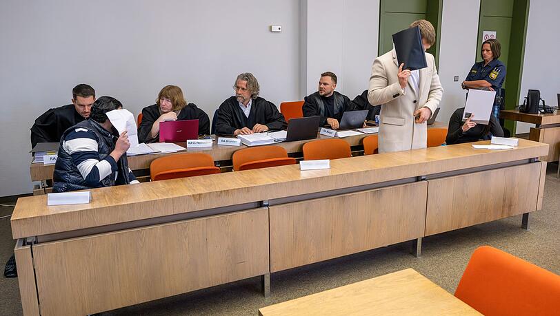 Die Angeklagten warten auf den Beginn ihres Prozesses.